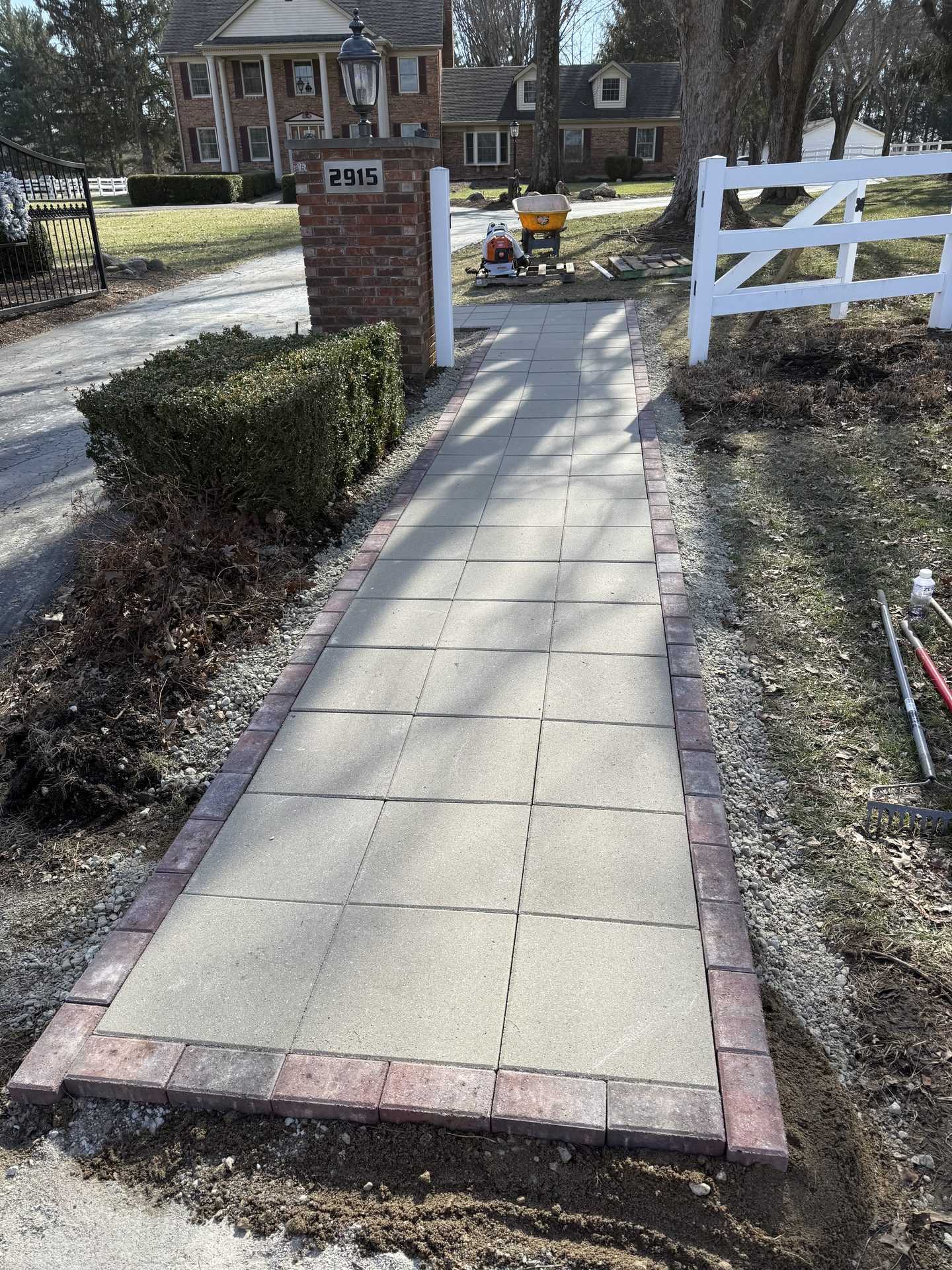 Paver walkway with red brick border and landscaping