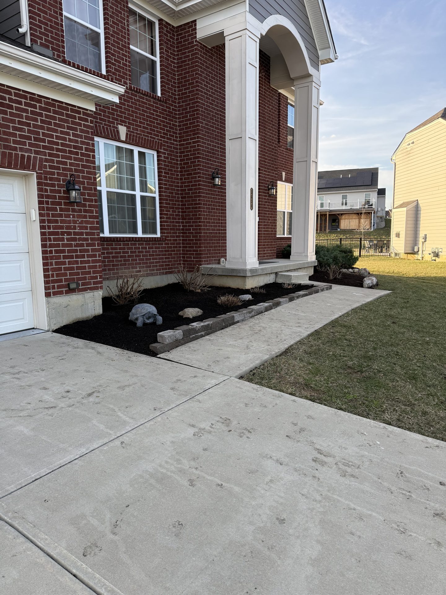 Fresh mulch beds along a brick home foundation