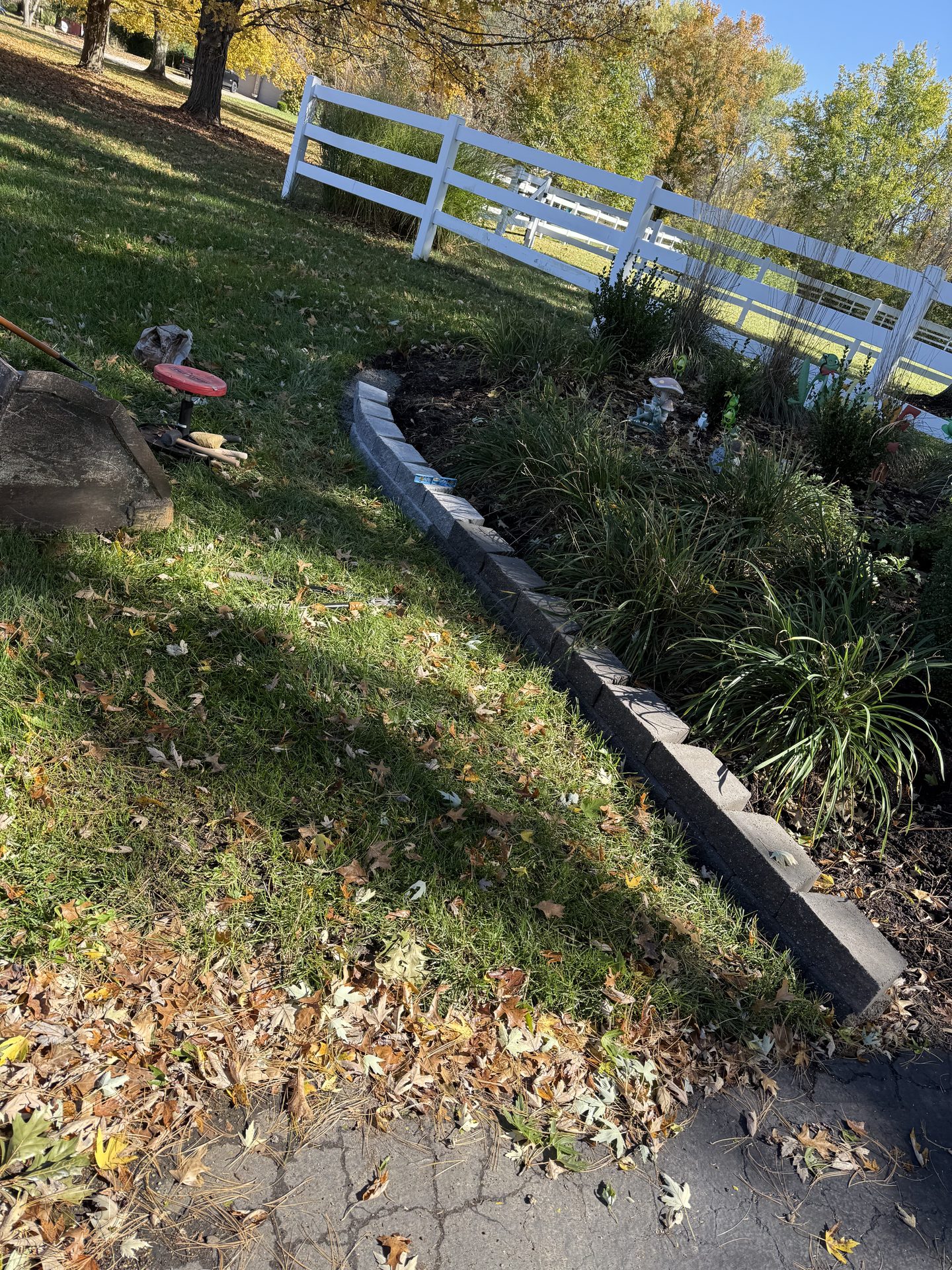 Landscape bed along a white fence line