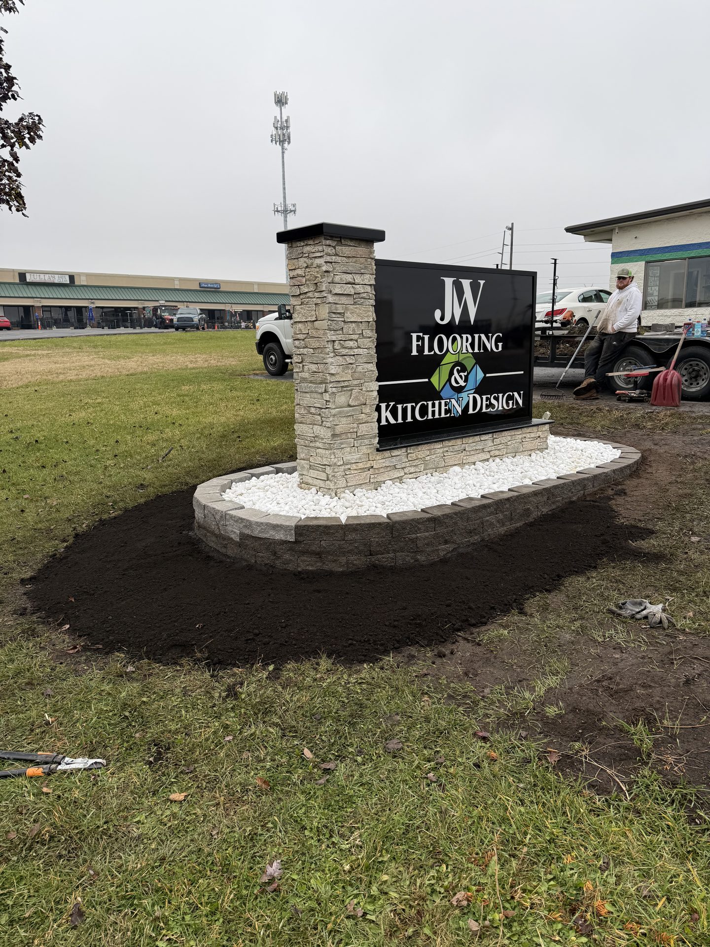 Commercial monument sign with stone base and landscaping