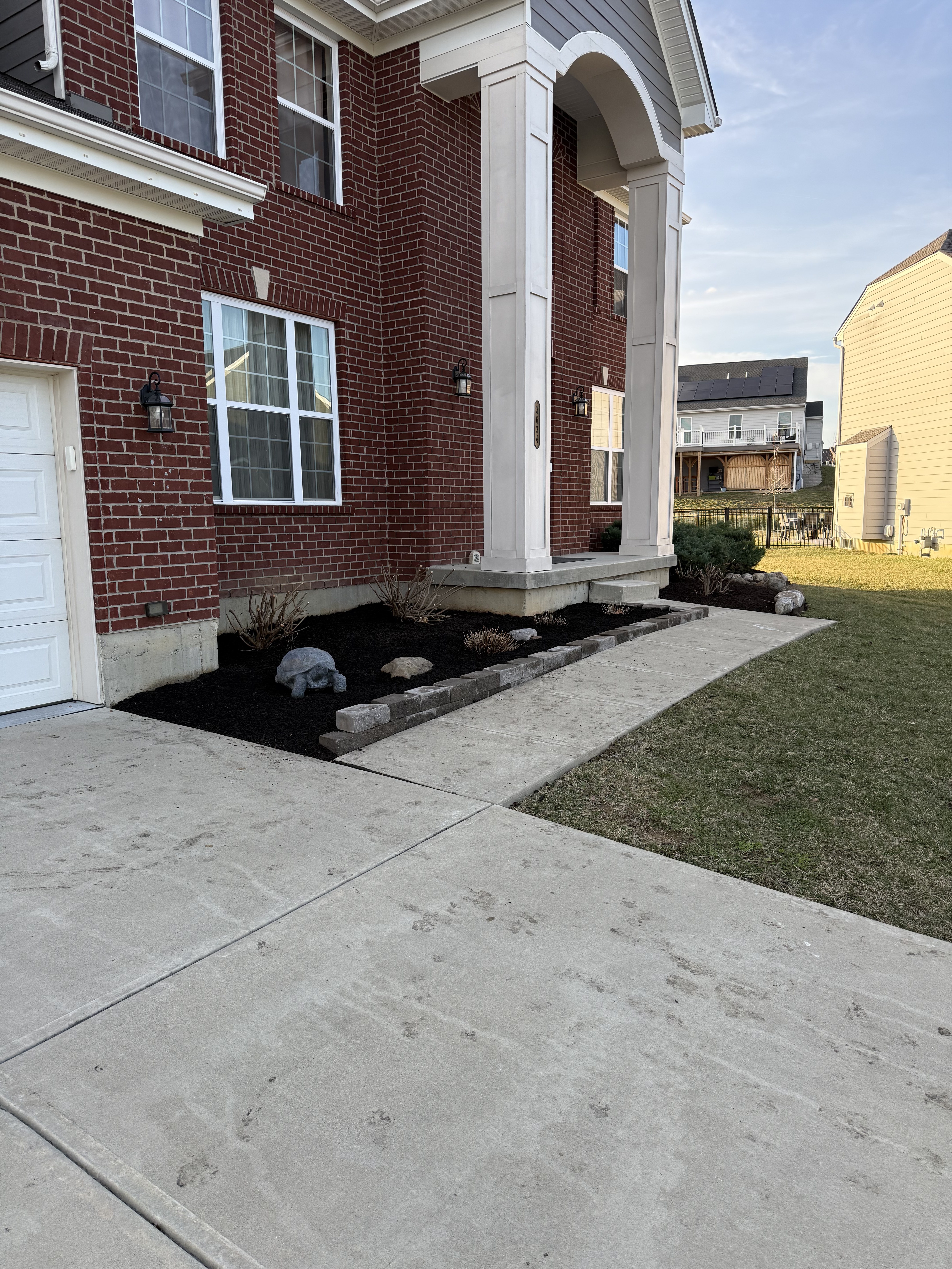 Complete foundation landscaping with black mulch and stone border