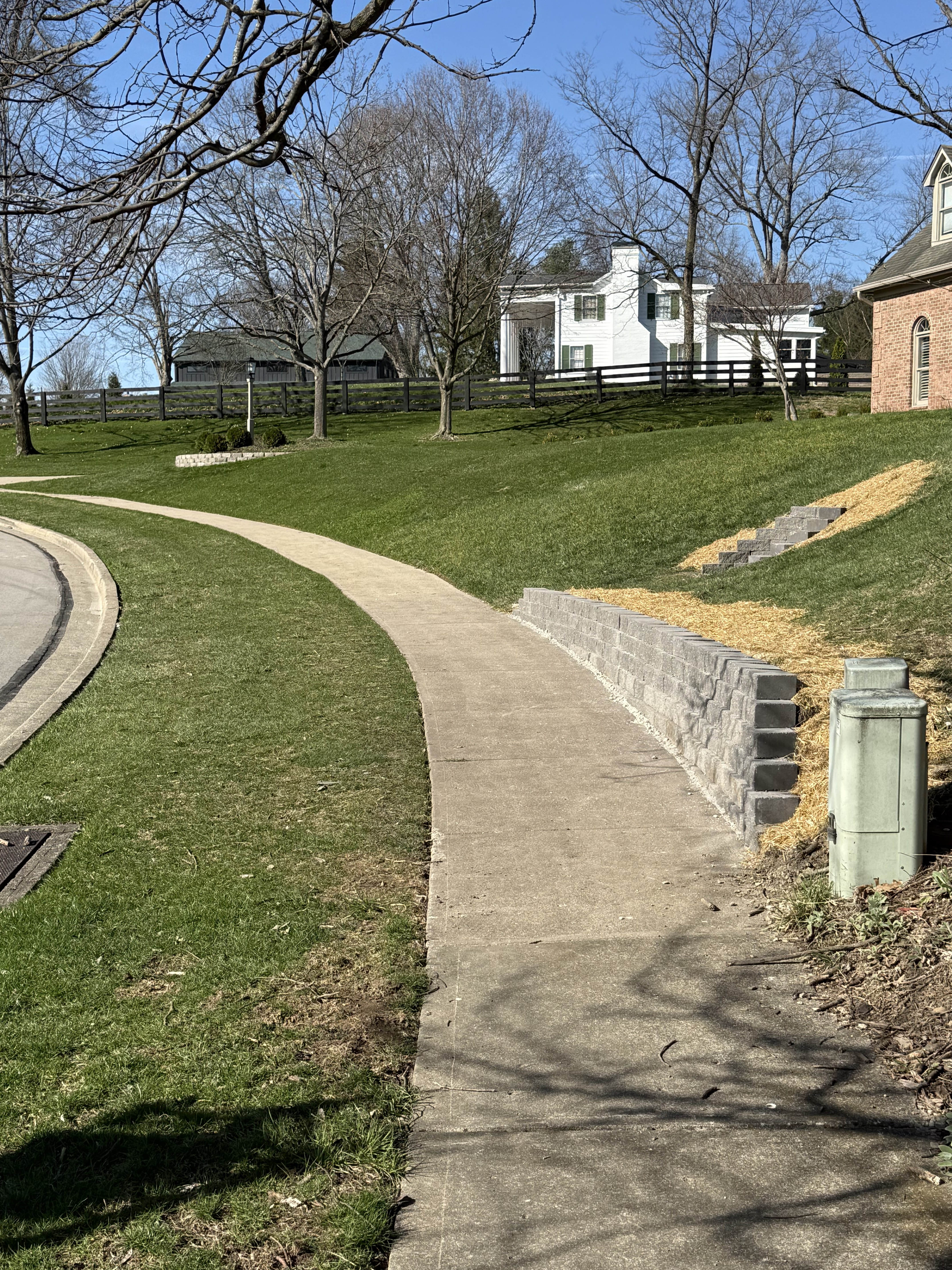 Curved stone landscape bed with shrub planting