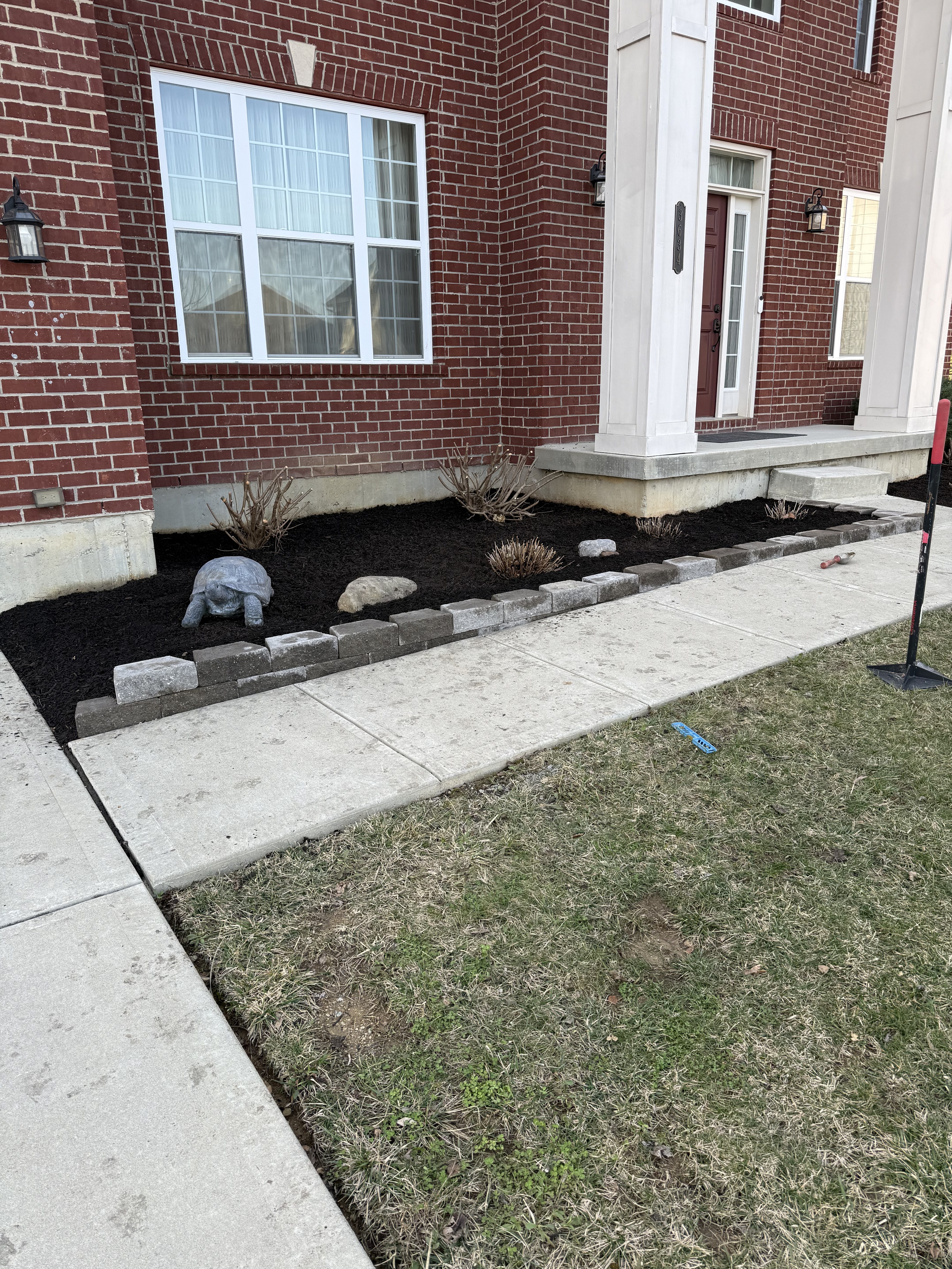 Foundation bed with black mulch and river rock border